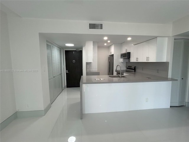 20335 W Country Club Dr Unit 903, Aventura, FL 33180 - kitchen with stainless steel appliances, a peninsula, a sink, white cabinetry, and recessed lighting