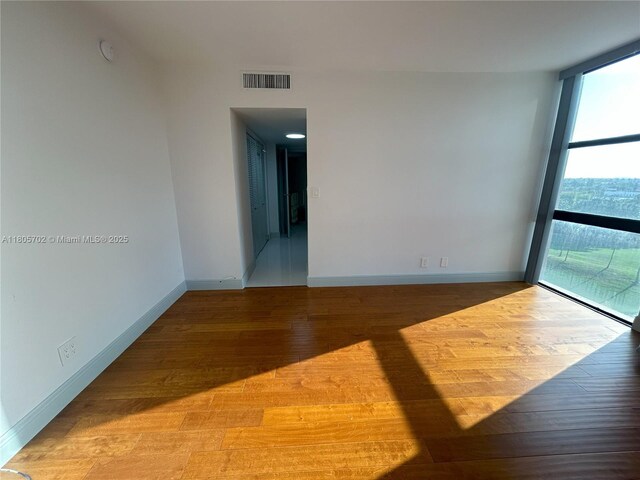 20335 W Country Club Dr Unit 903, Aventura, FL 33180 - unfurnished room with wood-type flooring, baseboards, and a wall of windows