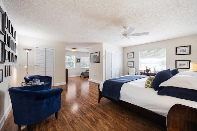 8610 SW 83rd St, Miami, FL 33143 - bedroom with dark wood-style flooring, two closets, a textured ceiling, baseboards, and ceiling fan