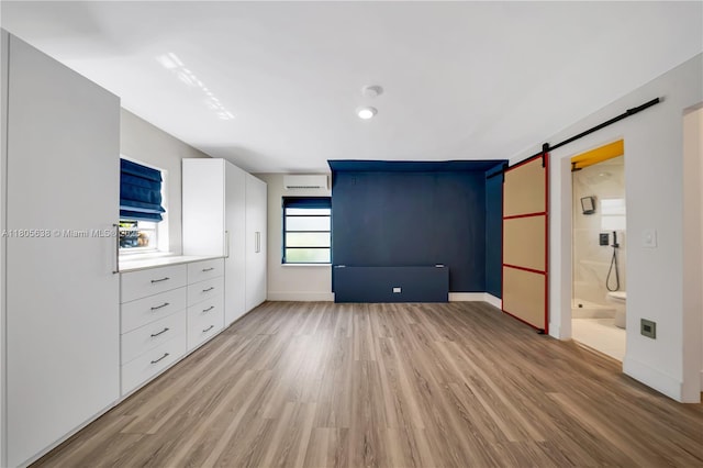 7411 Carlyle Ave, Miami Beach, FL 33141 - unfurnished bedroom with light wood-type flooring, a barn door, and baseboards