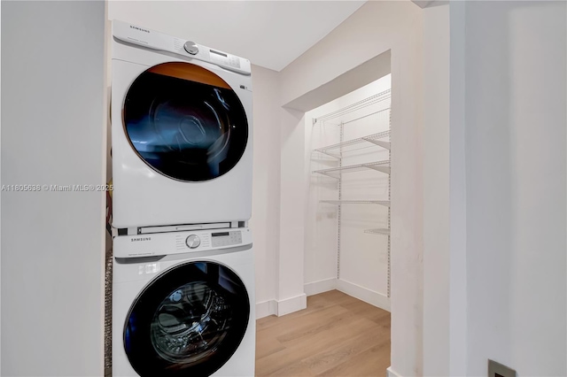 7411 Carlyle Ave, Miami Beach, FL 33141 - washroom with stacked washer / drying machine, light wood-style flooring, and baseboards
