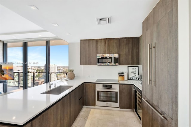 88 SW 7th St Unit 3212, Miami, FL 33130 - kitchen featuring stainless steel appliances, a sink, modern cabinets, a peninsula, and light countertops
