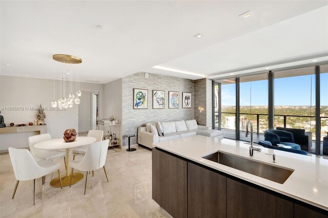 88 SW 7th St Unit 3212, Miami, FL 33130 - kitchen with open floor plan, a sink, dark brown cabinets, light countertops, and expansive windows