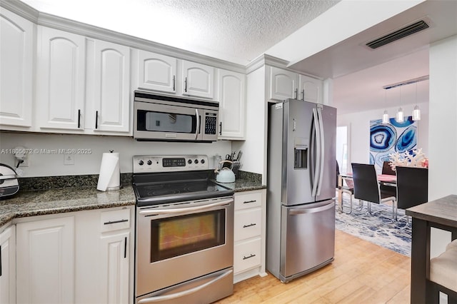 1500 S Ocean Dr Unit 7J, Hollywood, FL 33019 - kitchen featuring appliances with stainless steel finishes, light wood-type flooring, white cabinets, a textured ceiling, and decorative light fixtures