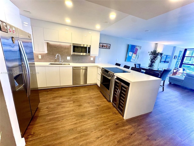 200 Leslie Dr Unit 817, Hallandale Beach, FL 33009 - kitchen featuring stainless steel appliances, a sink, wood finished floors, modern cabinets, and a peninsula