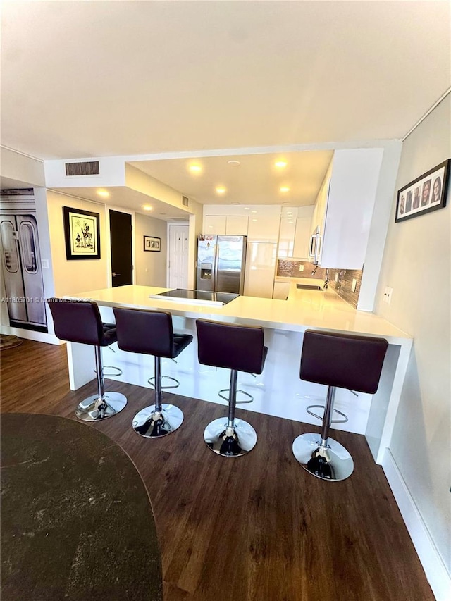 200 Leslie Dr Unit 817, Hallandale Beach, FL 33009 - kitchen with appliances with stainless steel finishes, dark wood-type flooring, a peninsula, white cabinetry, and a kitchen bar