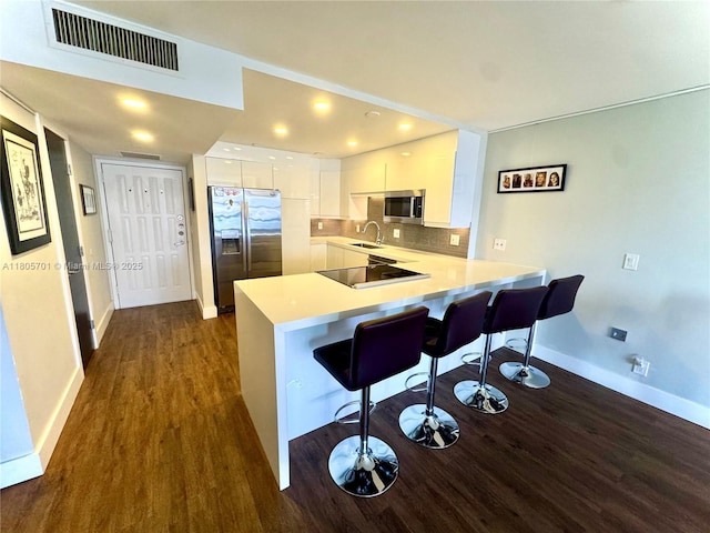 200 Leslie Dr Unit 817, Hallandale Beach, FL 33009 - kitchen featuring appliances with stainless steel finishes, a sink, a peninsula, dark wood-style flooring, and baseboards