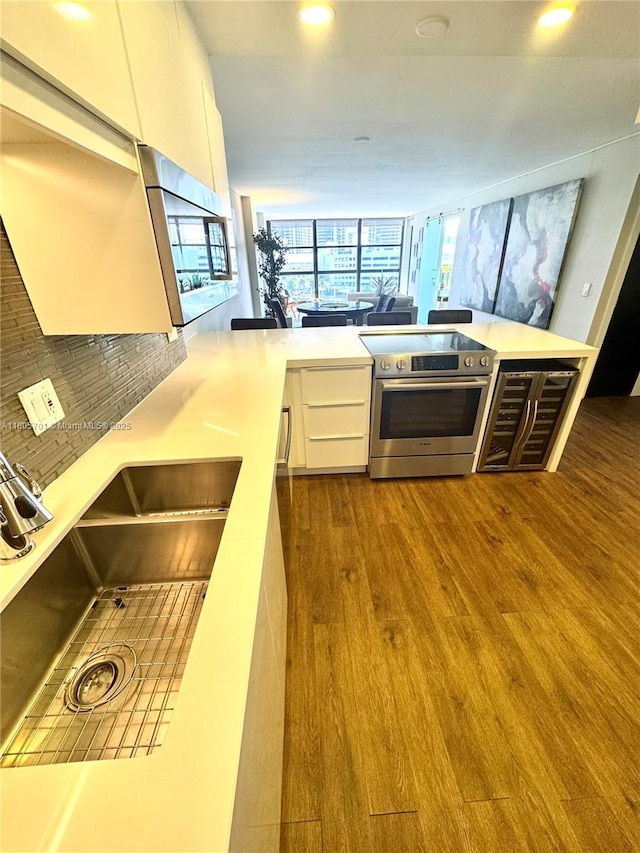 200 Leslie Dr Unit 817, Hallandale Beach, FL 33009 - kitchen featuring electric range, white cabinetry, wood finished floors, a sink, and recessed lighting