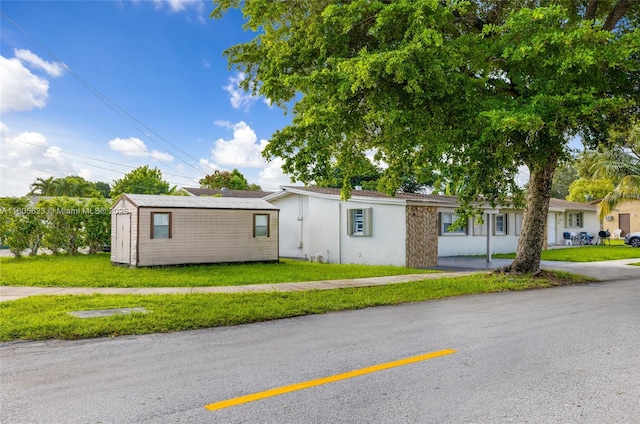5746 Polk St, Hollywood, FL 33021 - ranch-style house with a front yard, an outbuilding, and stucco siding