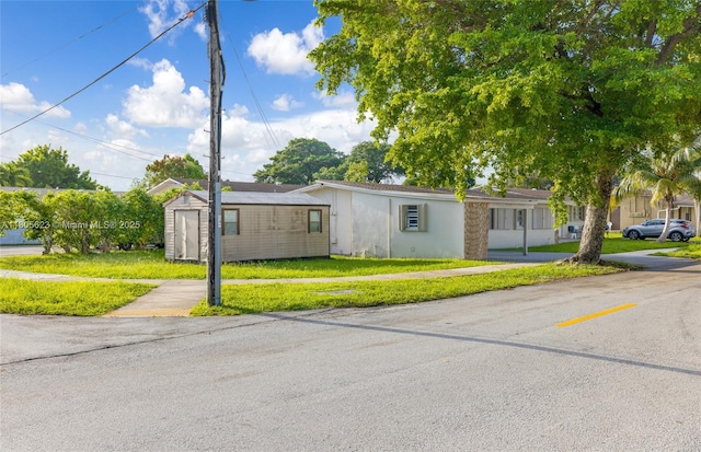 5746 Polk St, Hollywood, FL 33021 - ranch-style home with a storage unit, a front lawn, and an outbuilding