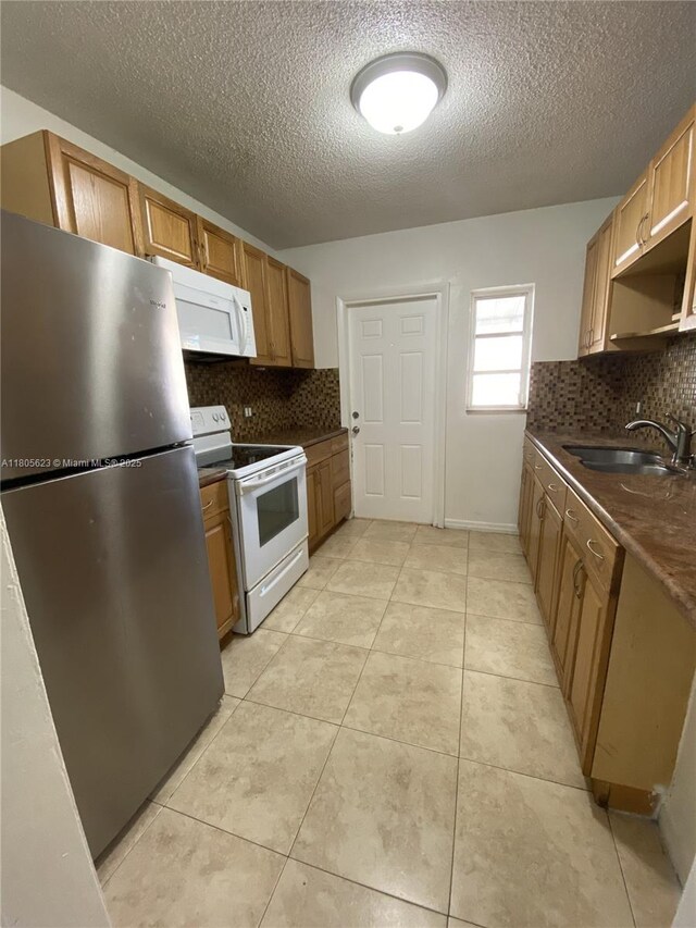 5746 Polk St, Hollywood, FL 33021 - kitchen featuring white appliances, a sink, dark countertops, decorative backsplash, and a textured ceiling