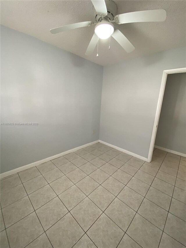 5746 Polk St, Hollywood, FL 33021 - empty room featuring a textured ceiling, light tile patterned floors, ceiling fan, and baseboards
