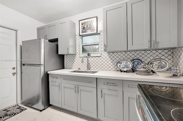 5437 NW 4th Ave, Miami, FL 33127 - kitchen featuring gray cabinetry, a sink, appliances with stainless steel finishes, tasteful backsplash, and light countertops