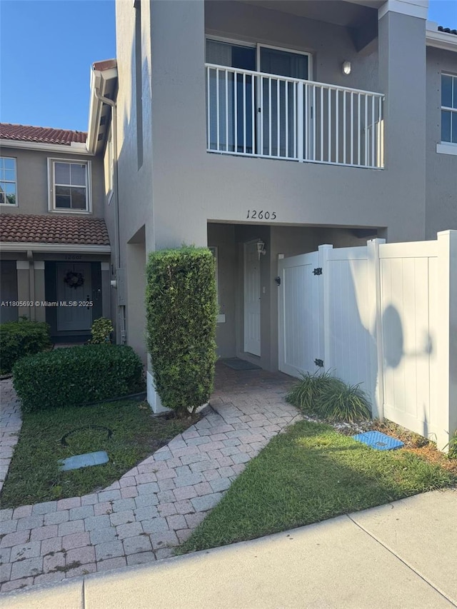12605 SW 54th Ct Unit 12605, Miramar, FL 33027 - view of front facade with stucco siding, fence, a balcony, and a tiled roof