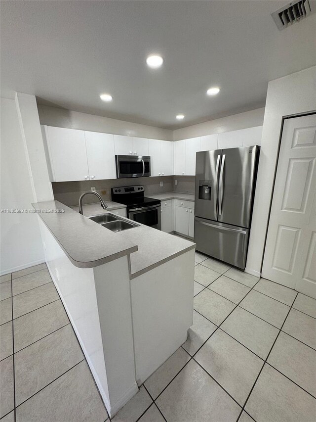 12605 SW 54th Ct Unit 12605, Miramar, FL 33027 - kitchen featuring stainless steel appliances, a sink, a peninsula, light countertops, and white cabinetry