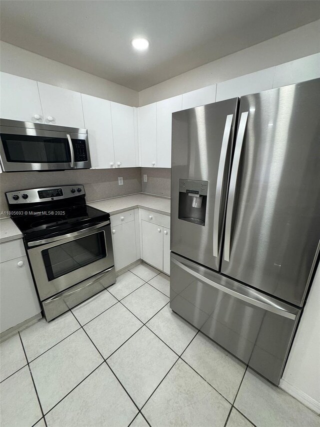 12605 SW 54th Ct Unit 12605, Miramar, FL 33027 - kitchen featuring appliances with stainless steel finishes, light countertops, white cabinetry, and light tile patterned floors