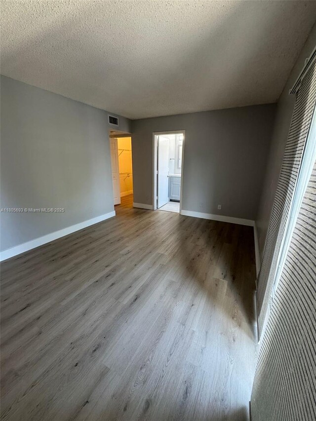 12605 SW 54th Ct Unit 12605, Miramar, FL 33027 - empty room with baseboards, wood finished floors, and a textured ceiling