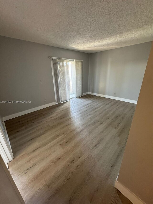 12605 SW 54th Ct Unit 12605, Miramar, FL 33027 - unfurnished room featuring wood finished floors, a textured ceiling, and baseboards