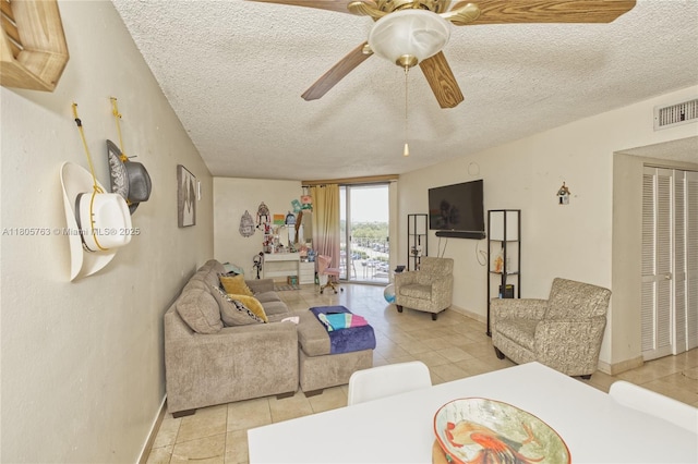 1750 W 46th St Unit 503, Hialeah, FL 33012 - living area featuring a textured ceiling, light tile patterned flooring, baseboards, and ceiling fan