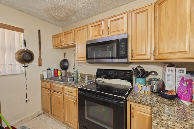 1750 W 46th St Unit 503, Hialeah, FL 33012 - kitchen featuring stainless steel microwave, black range with electric cooktop, a sink, light tile patterned floors, and a textured ceiling