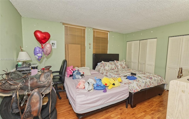 1750 W 46th St Unit 503, Hialeah, FL 33012 - bedroom with two closets, a textured ceiling, and wood finished floors