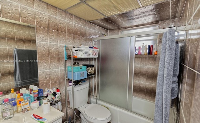1750 W 46th St Unit 503, Hialeah, FL 33012 - bathroom featuring tile walls, enclosed tub / shower combo, and toilet