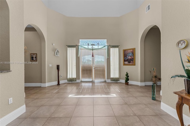 31725 SW 213th Ave, Homestead, FL 33030 - foyer entrance featuring a towering ceiling, light tile patterned floors, baseboards, and arched walkways
