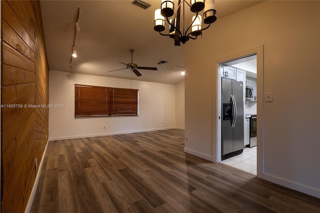 unfurnished room with wood finished floors, ceiling fan, a textured ceiling, baseboards, and track lighting