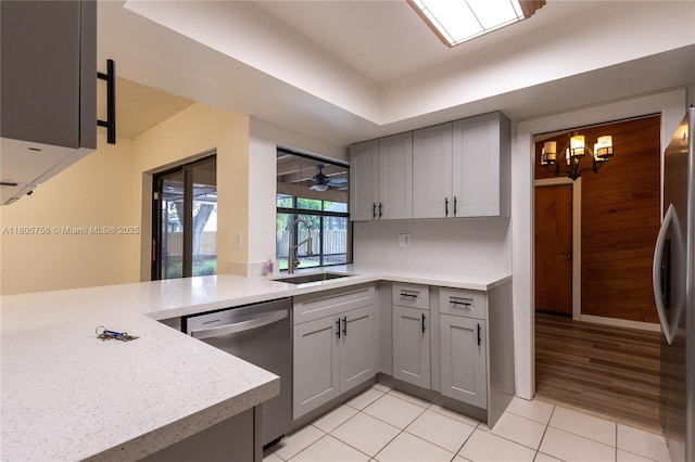 kitchen with a sink, stainless steel appliances, gray cabinets, and light countertops