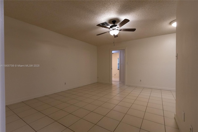 empty room with a textured ceiling, ceiling fan, and baseboards