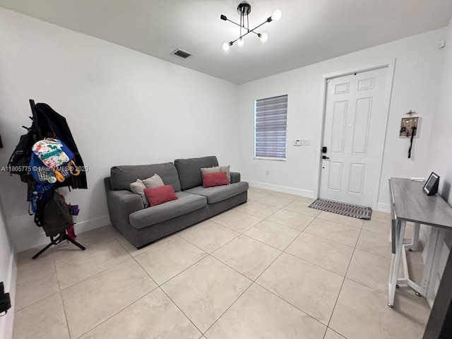 living room featuring light tile patterned floors, a chandelier, and baseboards