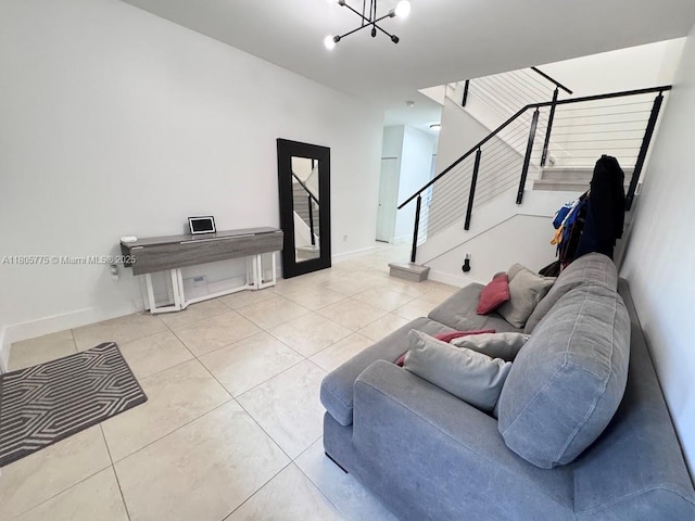 tiled living area with a chandelier, stairs, and baseboards