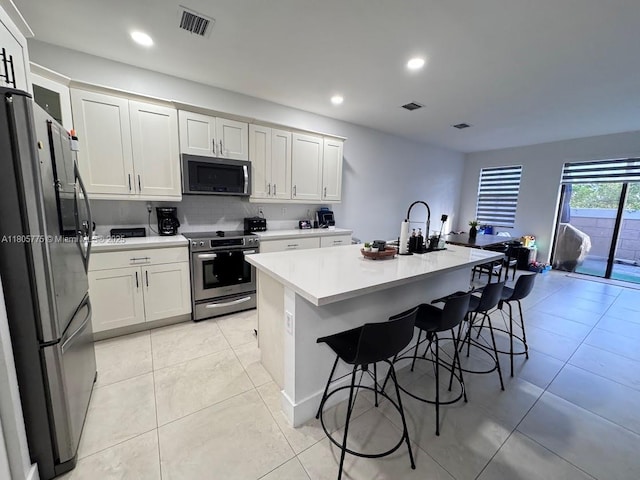 kitchen with appliances with stainless steel finishes, light countertops, white cabinetry, and recessed lighting