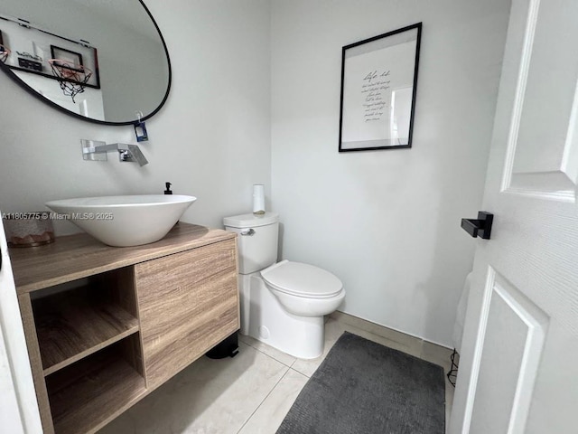 bathroom featuring toilet, tile patterned floors, vanity, and baseboards