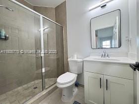 full bathroom featuring toilet, vanity, a stall shower, and tile patterned floors
