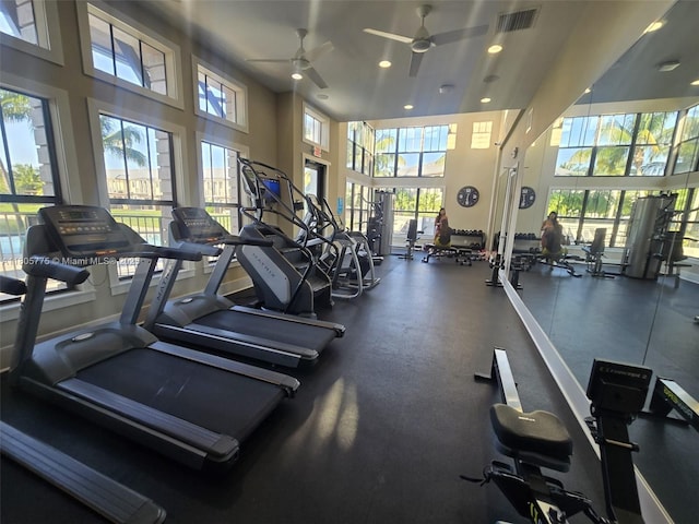 workout area with a ceiling fan, recessed lighting, and a towering ceiling