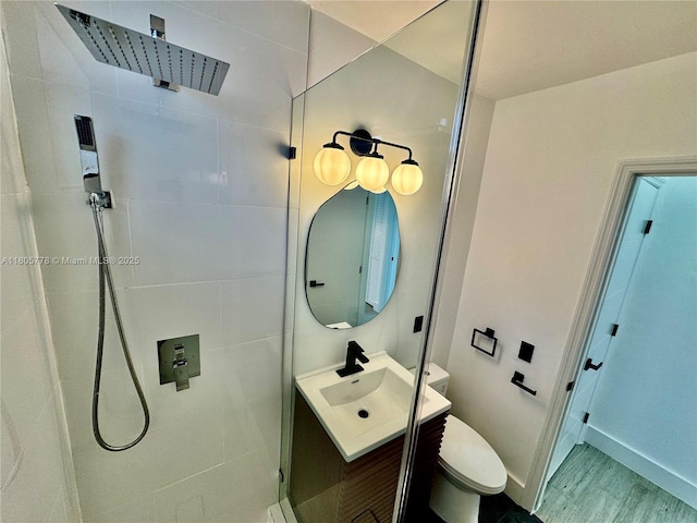 4710 Pine Tree Dr Unit 31, Miami Beach, FL 33140 - full bathroom with a tile shower, vanity, toilet, baseboards, and wood finished floors
