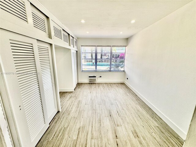 4710 Pine Tree Dr Unit 31, Miami Beach, FL 33140 - unfurnished bedroom featuring baseboards, light wood-style flooring, recessed lighting, and an AC wall unit