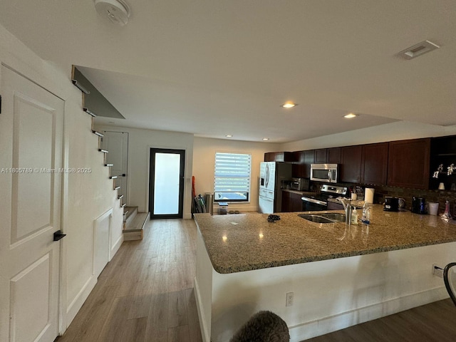 3720 NE 167th St Unit 39, North Miami Beach, FL 33160 - kitchen with stainless steel appliances, dark stone counters, a peninsula, a sink, and light wood-style floors