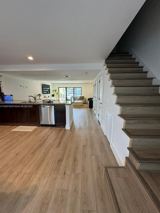 3720 NE 167th St Unit 39, North Miami Beach, FL 33160 - kitchen with stainless steel dishwasher, light wood finished floors, open floor plan, a sink, and dark brown cabinetry