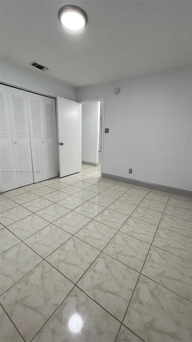 unfurnished bedroom with a closet and baseboards