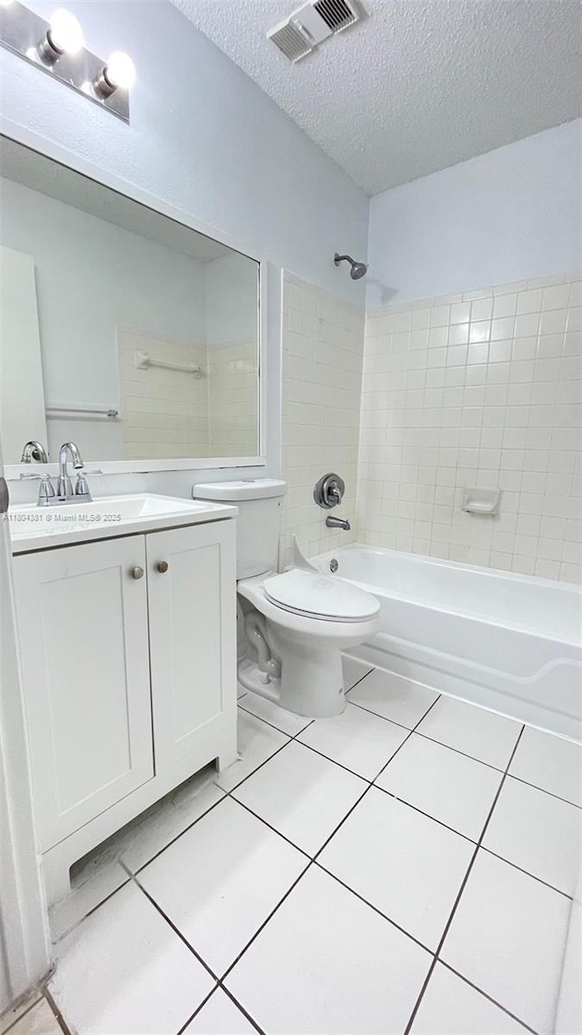 full bathroom with a textured ceiling, tile patterned floors, tub / shower combination, toilet, and vanity