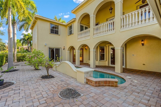 9192 Nugent Trl, West Palm Beach, FL 33411 - rear view of house featuring a balcony, stucco siding, and a patio