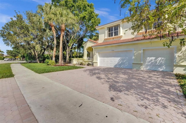 10730 NW 56th Ct, Coral Springs, FL 33076 - mediterranean / spanish home with decorative driveway, stucco siding, a tile roof, and a garage