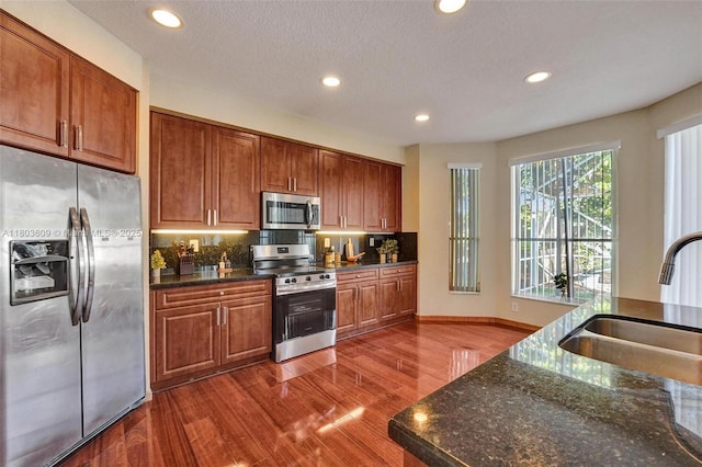 10730 NW 56th Ct, Coral Springs, FL 33076 - kitchen with stainless steel appliances, recessed lighting, dark wood finished floors, backsplash, and dark stone counters