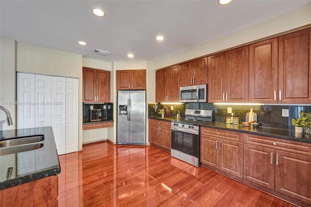 10730 NW 56th Ct, Coral Springs, FL 33076 - kitchen with appliances with stainless steel finishes, brown cabinetry, wood finished floors, and recessed lighting