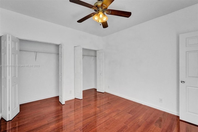 10730 NW 56th Ct, Coral Springs, FL 33076 - unfurnished bedroom featuring two closets, wood finished floors, and ceiling fan