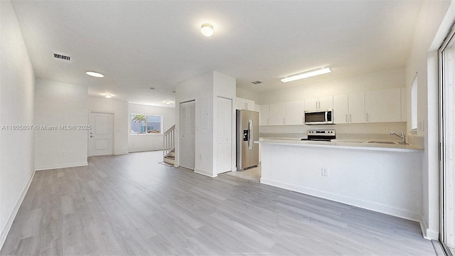 388 NW 12th Pl Unit 388, Florida City, FL 33034 - kitchen featuring stainless steel appliances, a sink, light countertops, open floor plan, and light wood-type flooring