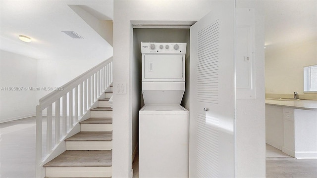 388 NW 12th Pl Unit 388, Florida City, FL 33034 - washroom featuring stacked washer and clothes dryer, light wood-type flooring, and baseboards