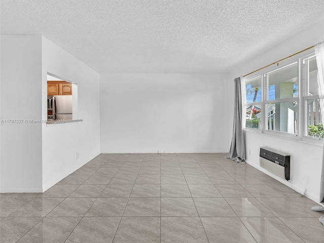 374 Tilford R Unit 374, Deerfield Beach, FL 33442 - empty room featuring a textured ceiling, heating unit, and light tile patterned floors